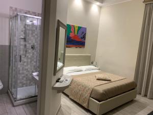 Residenza Suarez في نابولي: غرفة نوم بسرير ومرآة ودش