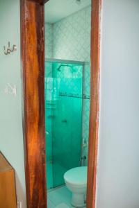 a bathroom with a toilet and a glass shower at Casa Salinópolis Atalaia in Salinópolis
