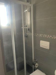 bagno con doccia in vetro e servizi igienici di Hotel Tyc Soleti Hotels a Rimini