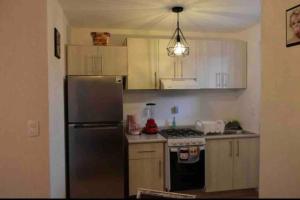 a kitchen with white cabinets and a stainless steel refrigerator at Cómodo Departamento in Machorra