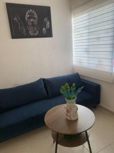 a blue couch in a living room with a table at Cómodo Departamento con Ubicación privilegiada 