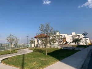un parc avec une aire de jeux et un bâtiment blanc dans l'établissement Cómodo Departamento con Ubicación privilegiada, 