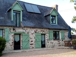 una casa con puertas verdes y techo negro en Chambre d hote La Roussiere en Saint-Ouen-des-Toits