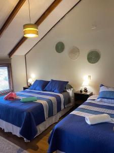 Felices Sueños, Entre Volcanes . في بورتو فاراس: غرفة نوم بسريرين مع شراشف زرقاء