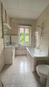 een badkamer met een bad, een toilet en een wastafel bij Studio vue sur Meuse in Namen