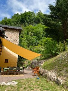 een gele patio met een tafel en stoelen en een gebouw bij B&B Il Mulino alla Busa in Vallarsa