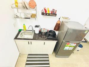 a small kitchen with a sink and a refrigerator at Cozy & Quiet 1BR Oasis in the heart of Ho Chi Minh City in Ho Chi Minh City