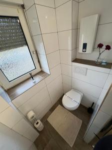 ein kleines Bad mit einem WC und einem Fenster in der Unterkunft Pluto in Gelsenkirchen