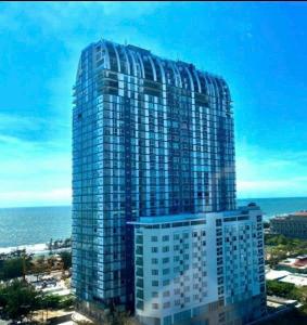 un grand bâtiment avec l'océan en arrière-plan dans l'établissement The Grand Condotel, à Vung Tau