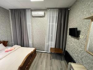 1 dormitorio con 1 cama y TV en la pared en STAR CITY Hostel en Kiev
