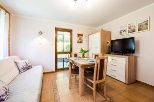 a living room with a dining room table and a tv at Morskie Chaty Platanowa in Rowy +39 photos