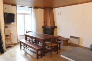 a dining room with a table and a fireplace at LES MIGLOU - Maison picarde entre Paris et la Champagne ! in Nogentel