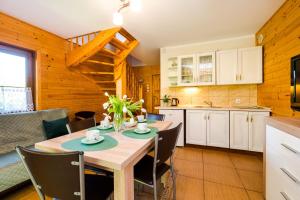 a kitchen and dining room with a table and chairs at Morskie Chaty Platanowa in Rowy