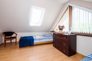 a bedroom with a bed and a dresser and a window at Morskie Chaty Platanowa in Rowy