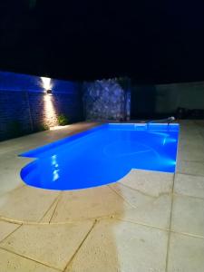 una piscina azul en un patio por la noche en el descanso en San Antonio de Areco