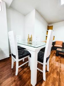 a white dining table with two chairs and a glass top at Como en tu casa apartamento oeste in Cali