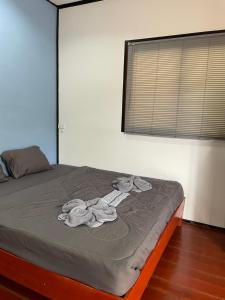 een bed met handdoeken in een slaapkamer bij Nuree Villa & Bungalow in Phra Ae beach