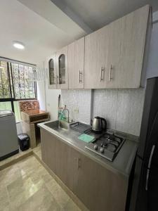 a kitchen with a sink and a stove top oven at Apartamento excepcional con excelente ubicación in Bello