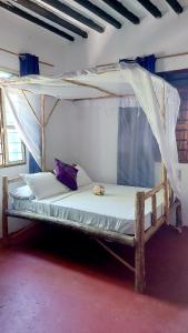 Bett mit Baldachin in einem Zimmer in der Unterkunft Jacob's Inn Jambiani in Jambiani