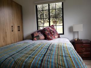 1 dormitorio con cama y ventana en Casita del páramo Sarmora, en La Calera