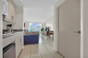 eine offene Küche und ein Wohnzimmer mit einem blauen Sofa in der Unterkunft Beautiful Blue & Gold Studio With Ocean View in Miami