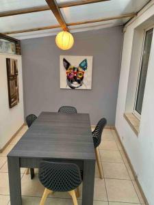 a dining room table with a cat picture on the wall at Maison avec terrasse au Havre in Le Havre