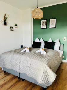 ein Schlafzimmer mit einem großen Bett und einer grünen Wand in der Unterkunft SH-Apartment Petra *zentral & stilvoll* in Erfurt