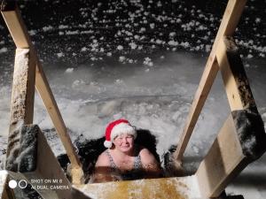 a woman wearing a santa hat in a hot tub at Villa Kanger in Kuusamo
