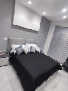 een slaapkamer met een zwart bed met witte kussens bij Maison Emma in Civitavecchia