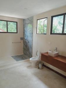 a bathroom with a toilet and a sink at Villas AHAL, in Chemuyil +54 photos