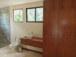 a bathroom with a toilet and a sink at Villa AHAL, in Chemuyil +53 photos