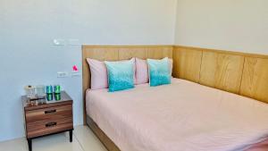 een slaapkamer met een bed met roze en blauwe kussens bij J-Double Room Xinzhuang District in Xinzhuang