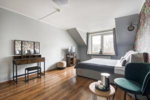 a bedroom with a bed and a desk and a chair at Apartamenty Stara Praga - Wiatraczna in Warsaw