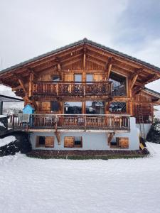 ein Blockhaus im Schnee mit einem großen Deck in der Unterkunft Grand chalet à la montagne in Bourg-Saint-Maurice
