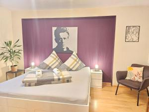 un dormitorio con una cama con una pintura de un hombre en Doppelzimmer 1 I geteiltes Bad & Küche I mit dem Zug nur 4 min bis zum Hauptbahnhof, en Freiburg im Breisgau