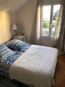 a bedroom with a large bed with a window at Ker Anna in Athis-Mons