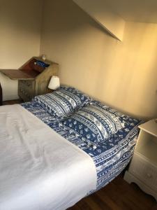 a bed with a blue and white comforter in a bedroom at Ker Anna in Athis-Mons