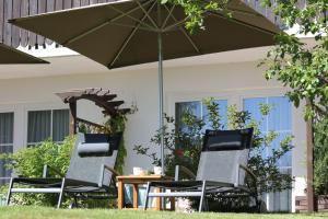 two chairs and a table under an umbrella at Hotel Tannhof in Feldberg