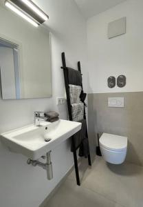 a bathroom with a sink and a toilet and a mirror at Stilvolles Ferinen-Apartment im Herzen von Xanten in Xanten