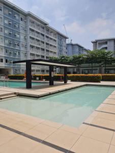 マニラにあるStaycation in Quezon City by DJ 143 with pool and PS5の大きな建物の前のプール