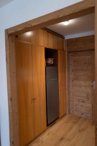 kuchnia z drewnianymi szafkami i lodówką w obiekcie White Escape w mieście Valtournenche +14 zdjęć