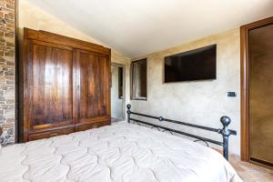 1 dormitorio con 1 cama y TV en la pared en Il Cantuccio Toscano, en Palaia