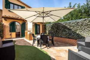un patio con mesa y sombrilla en Il Cantuccio Toscano, en Palaia
