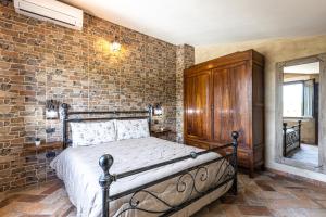 1 dormitorio con cama y pared de ladrillo en Il Cantuccio Toscano, en Palaia