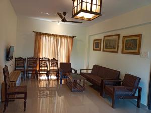 a living room with a couch and chairs and a table at Ronne's aparthotel in Arpora