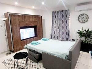 a hospital room with a bed and a clock on the wall at New&Cosy Apartment with Balcony in San Ġwann