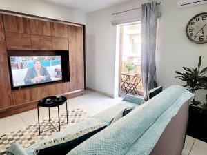 a living room with a couch and a tv at New&Cosy Apartment with Balcony in San Ġwann