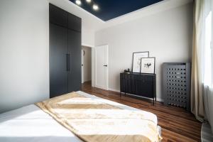 a bedroom with a bed and a black cabinet at Apartament Premium 25 Czerwca in Radom