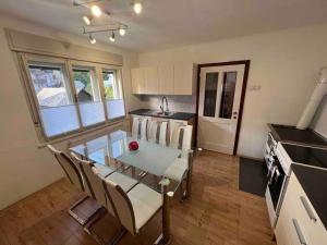 a kitchen with a glass table and chairs and a stove at Tiny Bled house in Bled