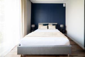 a bedroom with a large bed with blue walls at Apartament Premium 25 Czerwca in Radom